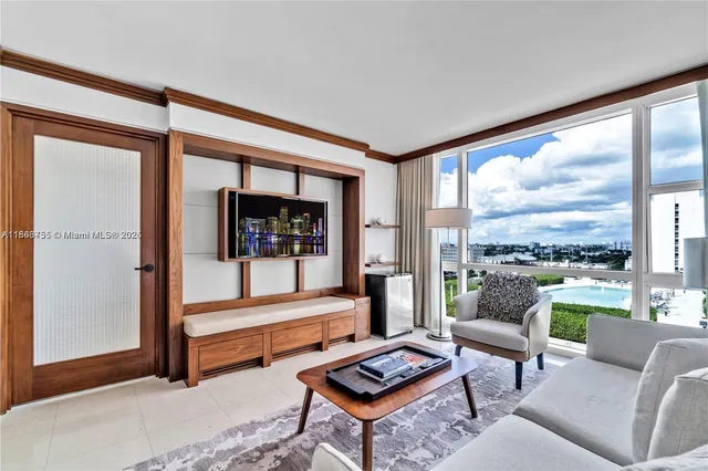 a living room with furniture and a floor to ceiling window