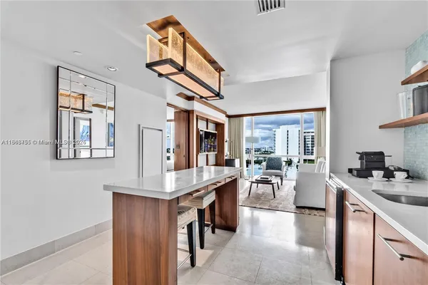 a kitchen with stainless steel appliances granite countertop a stove oven a dining table and chairs with wooden floor