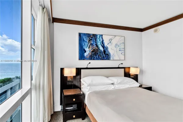 a bedroom with a bed and a painting on the wall