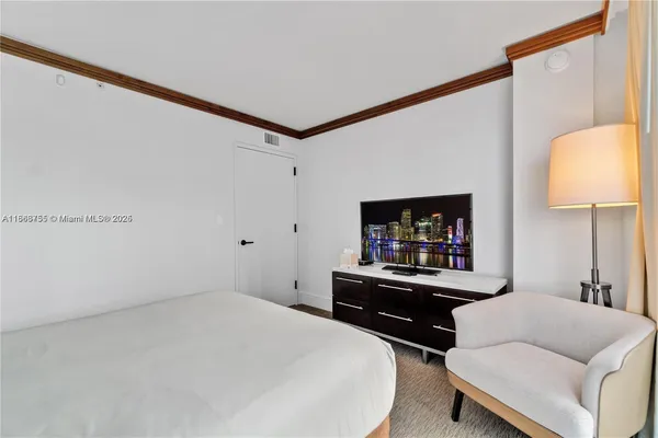 a bedroom with a bed and a flat screen tv