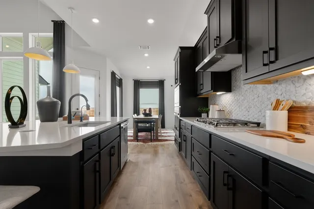 a kitchen with stainless steel appliances a sink cabinets and wooden floor
