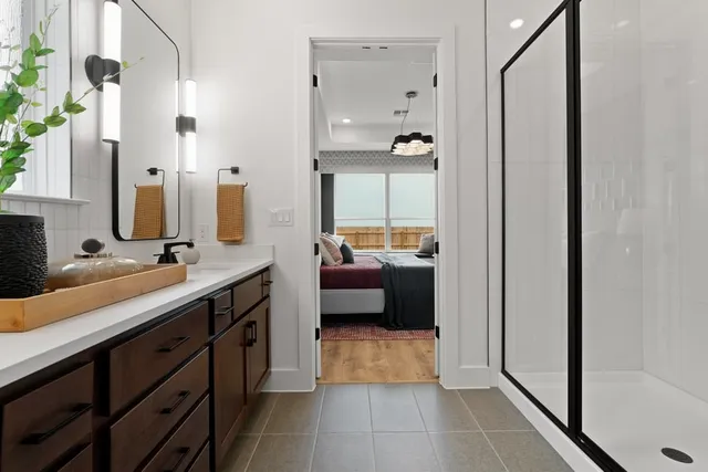 a spacious bathroom with a double vanity sink a mirror and a shower