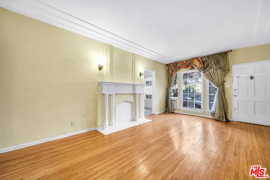 9000 Burton Way Beverly Hills, CA 90211 - Photo 14 of 26 a view of an empty room with wooden floor and a window