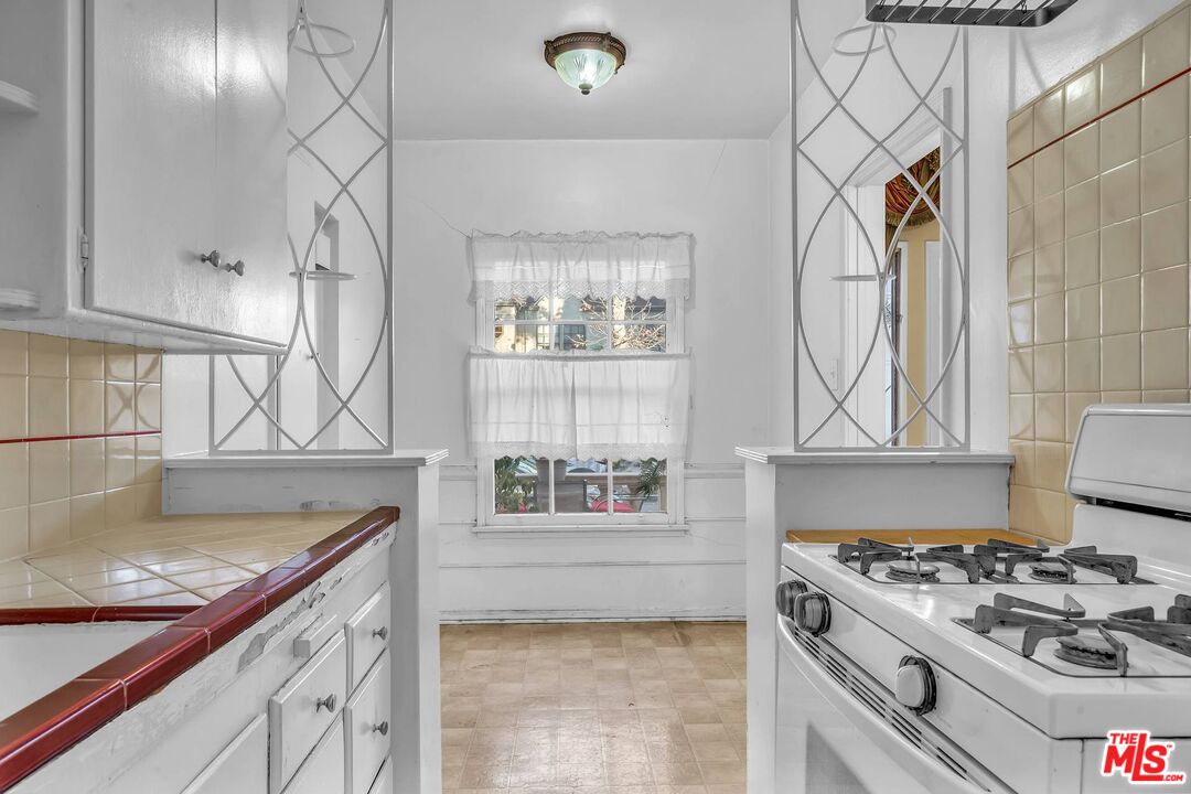 9000 Burton Way Beverly Hills, CA 90211 - Photo 16 of 26 a kitchen with stainless steel appliances granite countertop a stove a sink and a microwave
