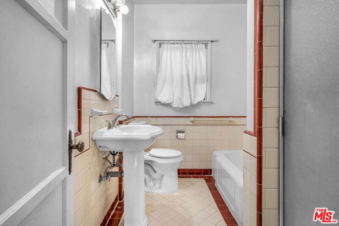 9000 Burton Way Beverly Hills, CA 90211 - Photo 17 of 26 a bathroom with a sink a toilet and mirror