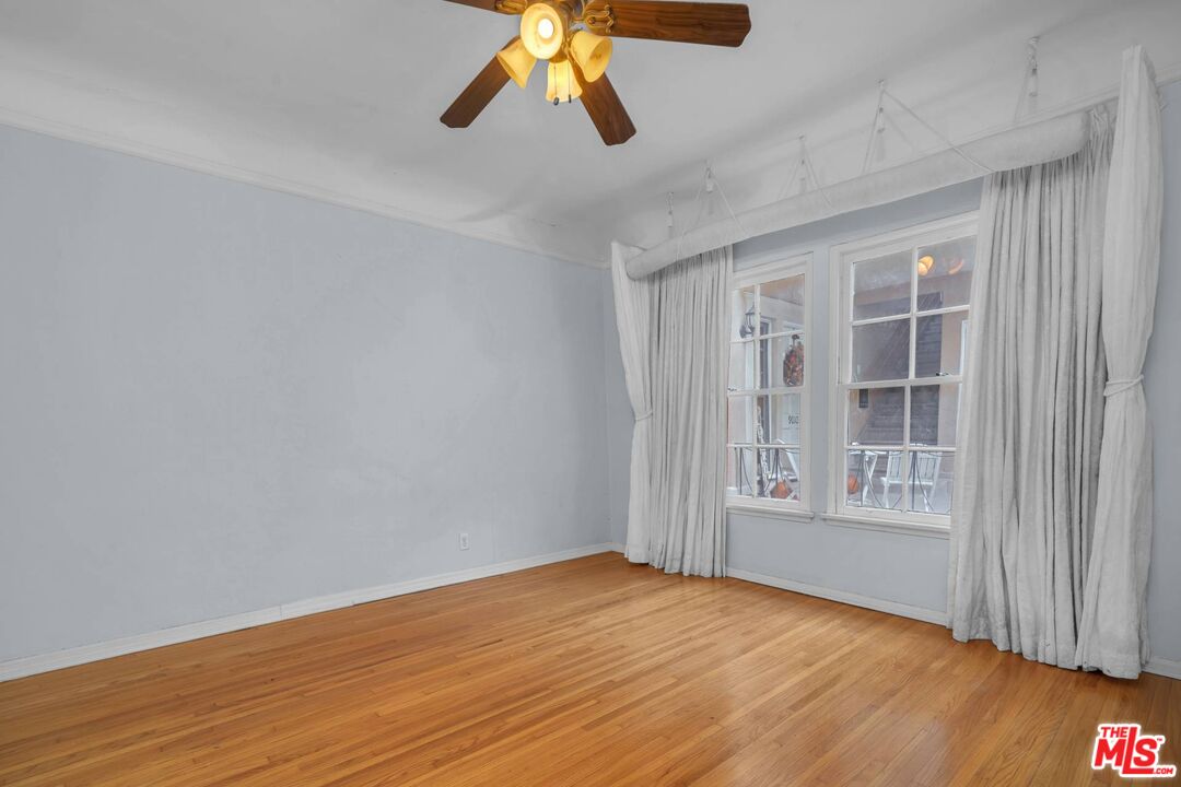 9000 Burton Way Beverly Hills, CA 90211 - Photo 18 of 26 a view of an empty room with wooden floor and a window