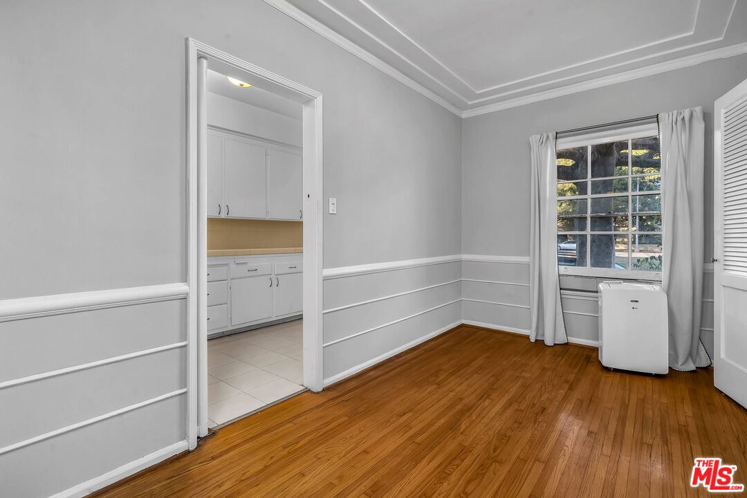 9000 Burton Way Beverly Hills, CA 90211 - Photo 6 of 26 a view of an empty room with a window and wooden floor