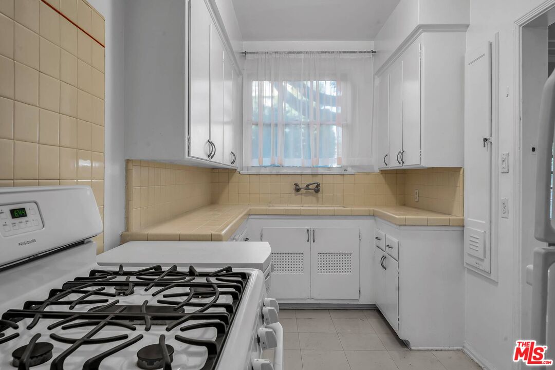 9000 Burton Way Beverly Hills, CA 90211 - Photo 8 of 26 a kitchen with a stove and a white cabinet