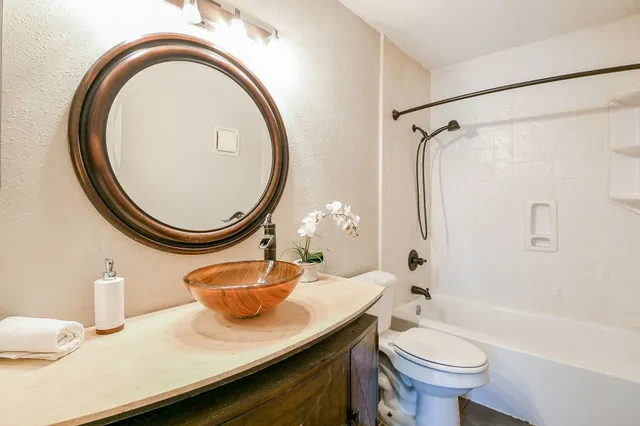 a bathroom with a sink a toilet and a mirror