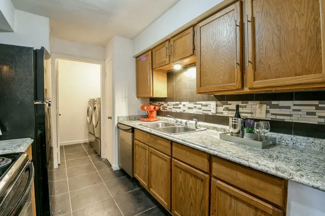 a kitchen with stainless steel appliances granite countertop a sink stove and cabinets