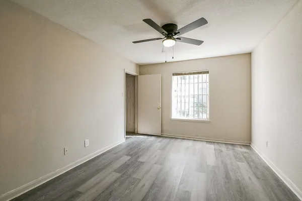 a view of a big room with wooden floor and windows