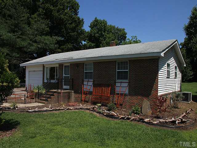 4812 Tryon Road Raleigh, NC 27606 - Photo 1 of 12 a backyard of a house with table and chairs with plants and garden