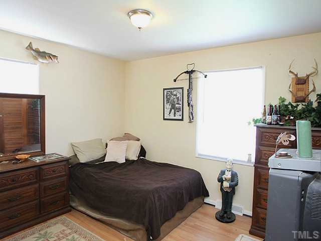 4812 Tryon Road Raleigh, NC 27606 - Photo 7 of 12 a bedroom with a bed and wooden floor