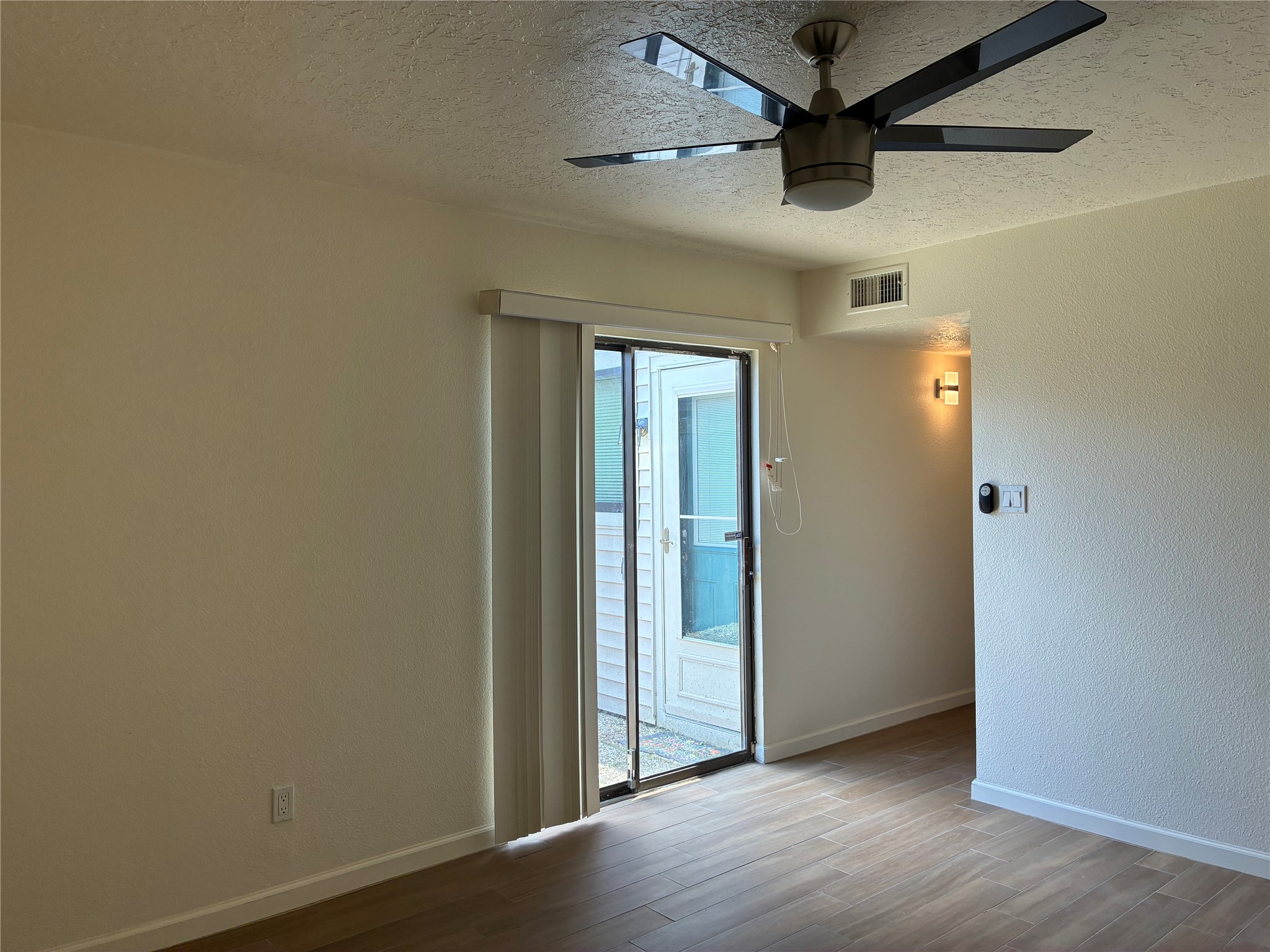 6401 Deihl Road, Unit 1011 Houston, TX 77092 - Photo 13 of 16 an empty room with a ceiling fan and wooden floor