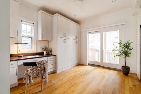 a kitchen with a table chairs refrigerator and window