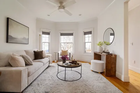a living room with furniture a window and a chandelier