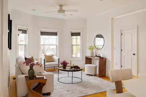 a living room with furniture a fireplace and a window