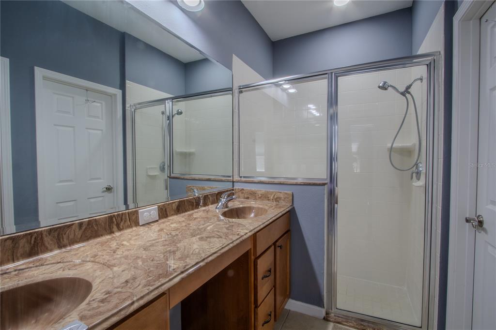 762 Terrace Spring Drive Orlando, FL 32828 - Photo 16 of 26 a bathroom with a granite countertop sink a mirror and a shower