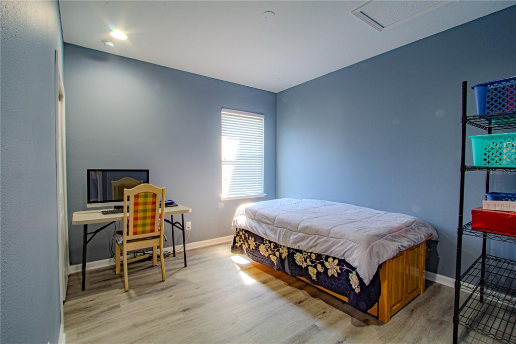 762 Terrace Spring Drive Orlando, FL 32828 - Photo 19 of 26 a bedroom with a bed and a table in it