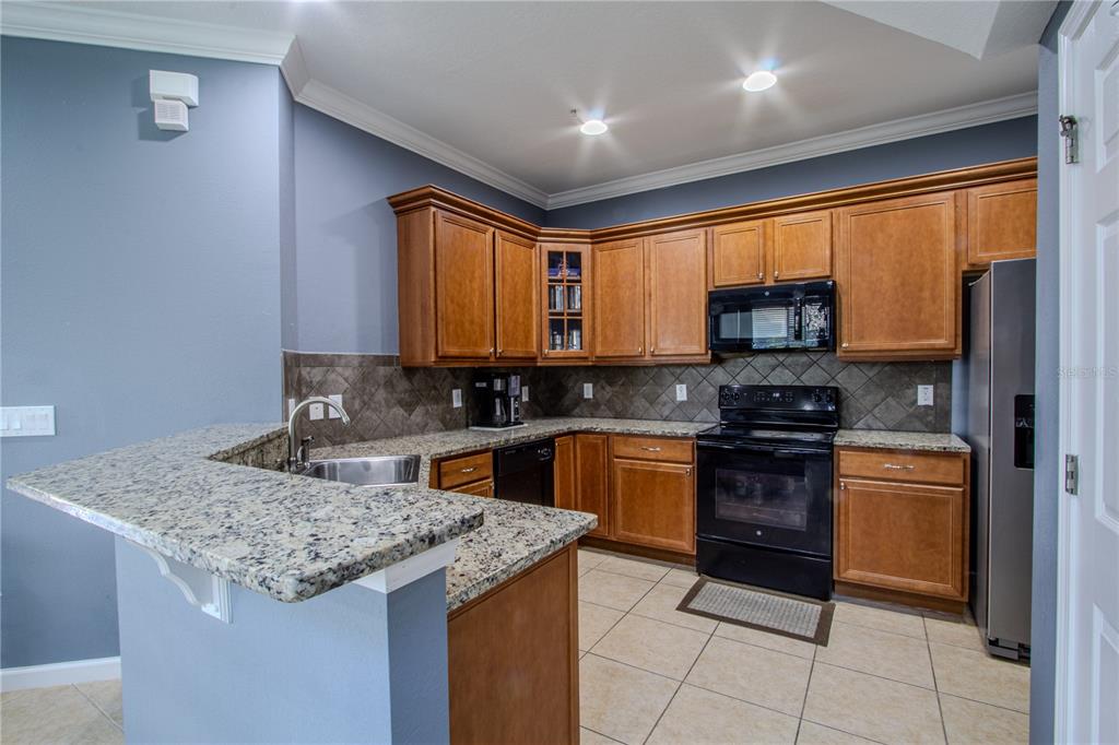 762 Terrace Spring Drive Orlando, FL 32828 - Photo 2 of 26 a kitchen with stainless steel appliances granite countertop a stove sink and microwave