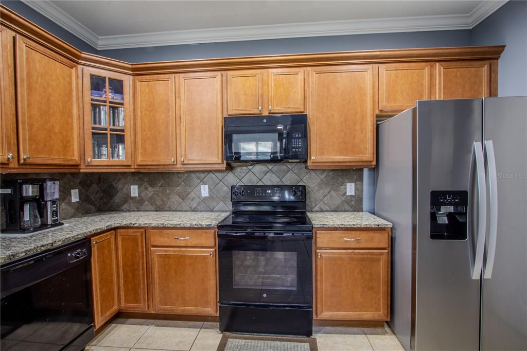 762 Terrace Spring Drive Orlando, FL 32828 - Photo 3 of 26 a kitchen with stainless steel appliances granite countertop a refrigerator and a stove