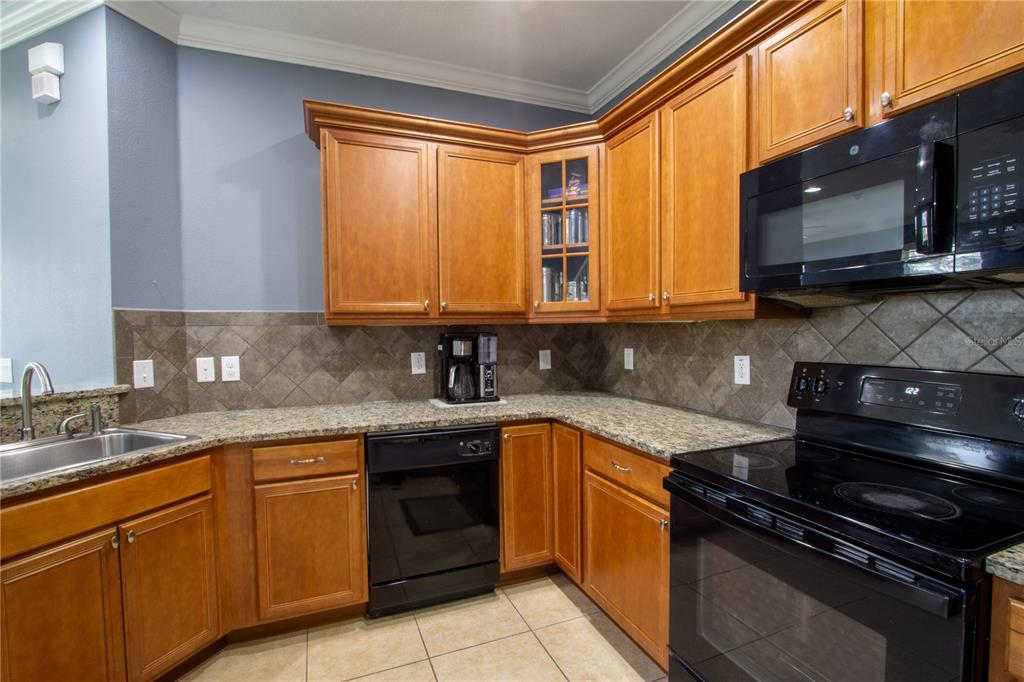 762 Terrace Spring Drive Orlando, FL 32828 - Photo 5 of 26 a kitchen with stainless steel appliances granite countertop white cabinets granite counter tops and a window