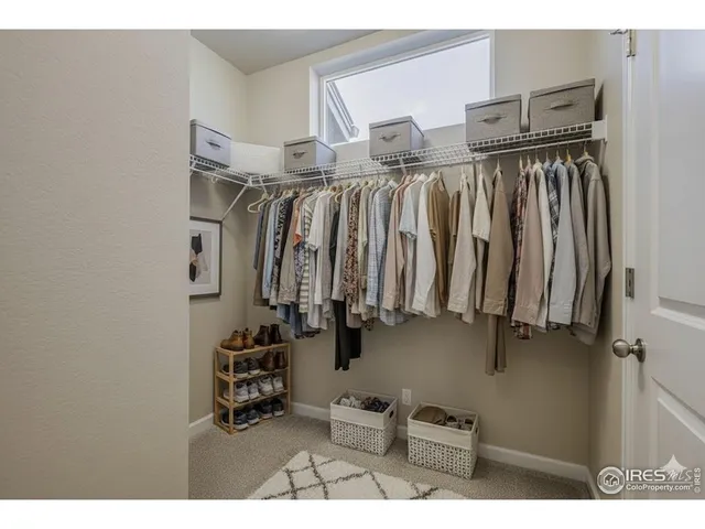 a view of walk in closet with clothes and shoes