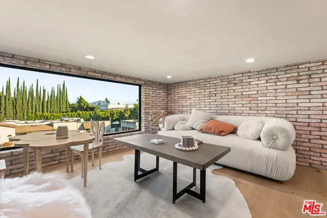 a living room with furniture and two large window