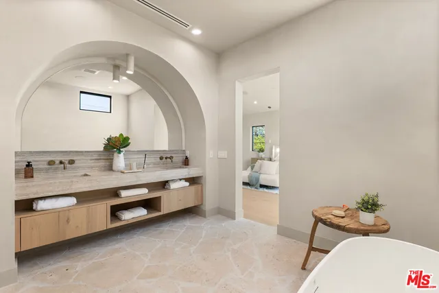 a bathroom with a granite countertop double vanity sink and mirror