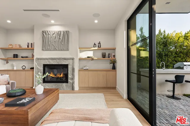 a living room with furniture a large window and wooden floor