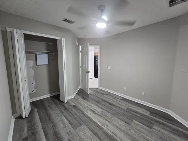 an empty room with wooden floor and closet