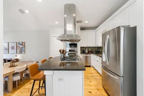 a kitchen with stainless steel appliances granite countertop a sink refrigerator and cabinets