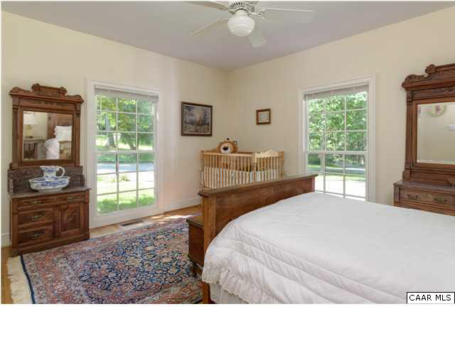 871 Tanglewood Road Charlottesville, VA 22901 - Photo 16 of 33 a bedroom with a bed and wooden floor