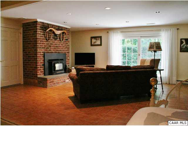 871 Tanglewood Road Charlottesville, VA 22901 - Photo 31 of 33 a living room with furniture a fireplace and a flat screen tv
