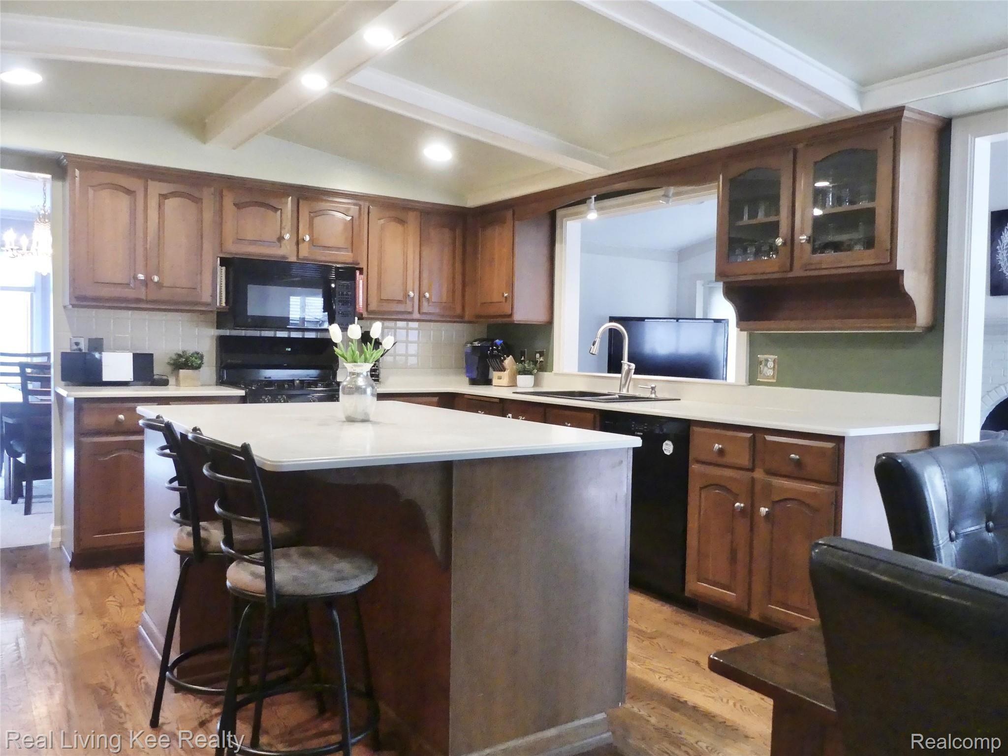 Large custom kitchen with cherry cabinets, corian counters, vaulted ceiling