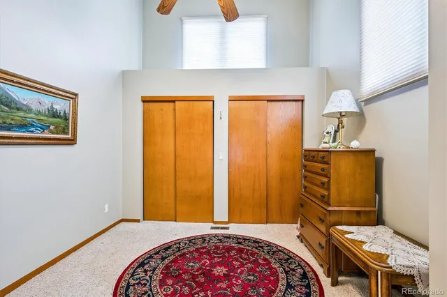 a bedroom with a bed and teddy bear on bed
