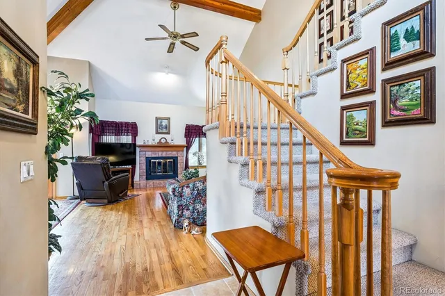 a view of a livingroom with furniture a fireplace a chandelier and wooden floor