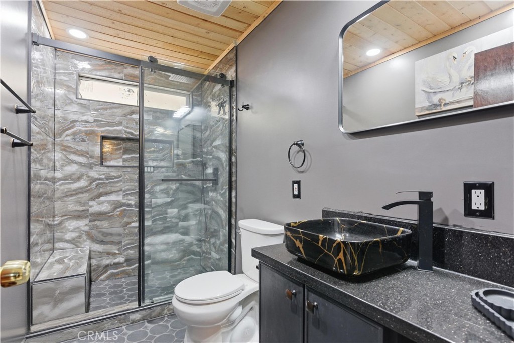 381 B Street Arvin, CA 93203 - Photo 13 of 23 a bathroom with a granite countertop sink a toilet and a shower