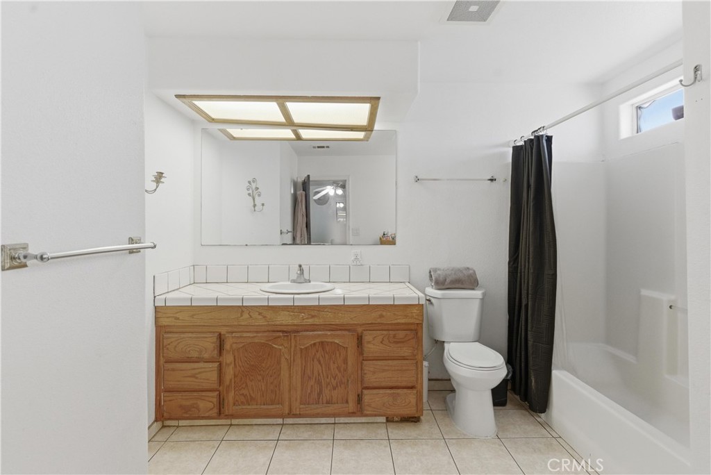 381 B Street Arvin, CA 93203 - Photo 16 of 23 a bathroom with a granite countertop sink a toilet and a mirror