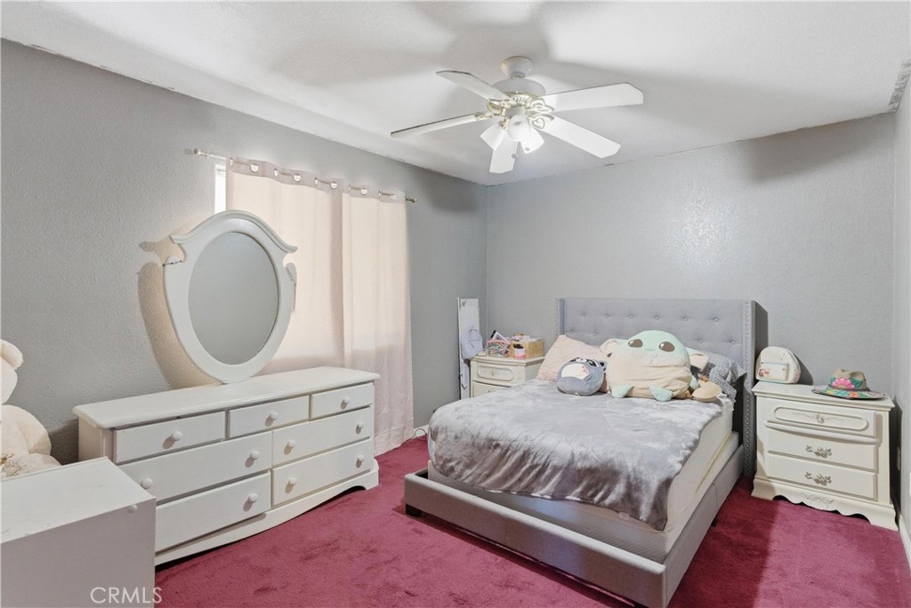 381 B Street Arvin, CA 93203 - Photo 18 of 23 a bedroom with a bed a mirror on dresser and a chandelier