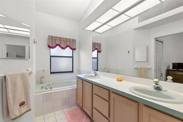 a bathroom with a granite countertop sink mirror and bathtub