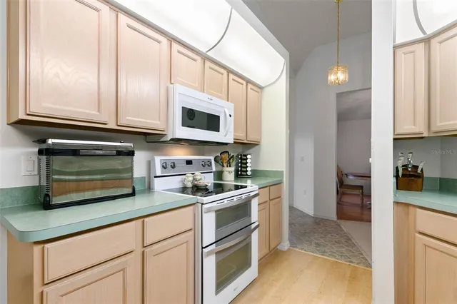 a kitchen with stainless steel appliances granite countertop white cabinets a stove a microwave and a refrigerator