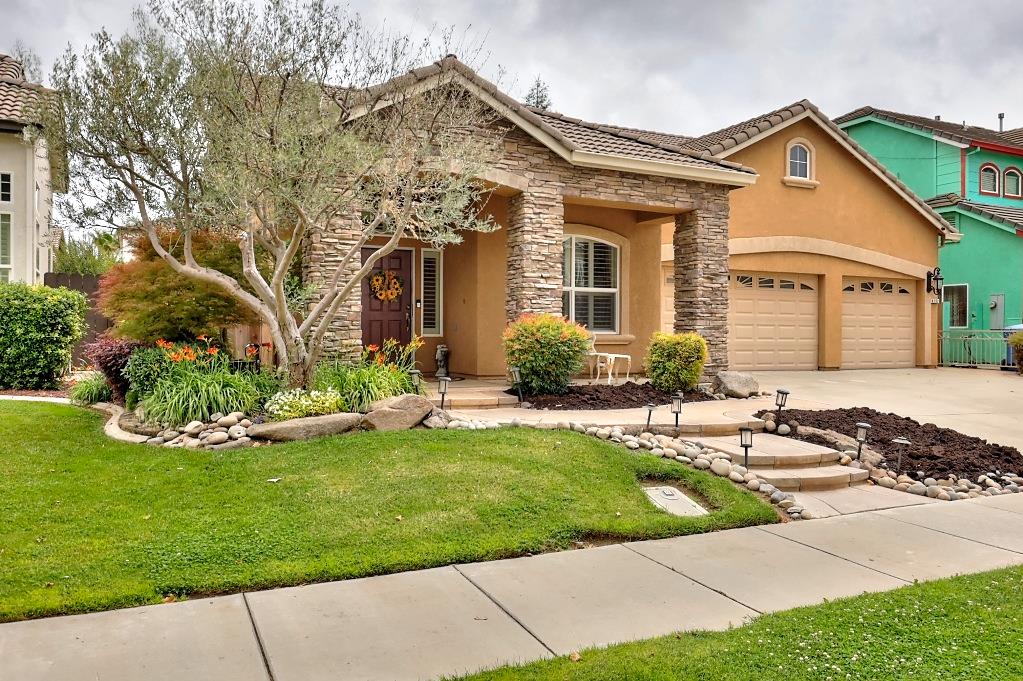 4152 Post Oak Drive Turlock, CA 95382 - Photo 2 of 71 a front view of a house with a garden and plants