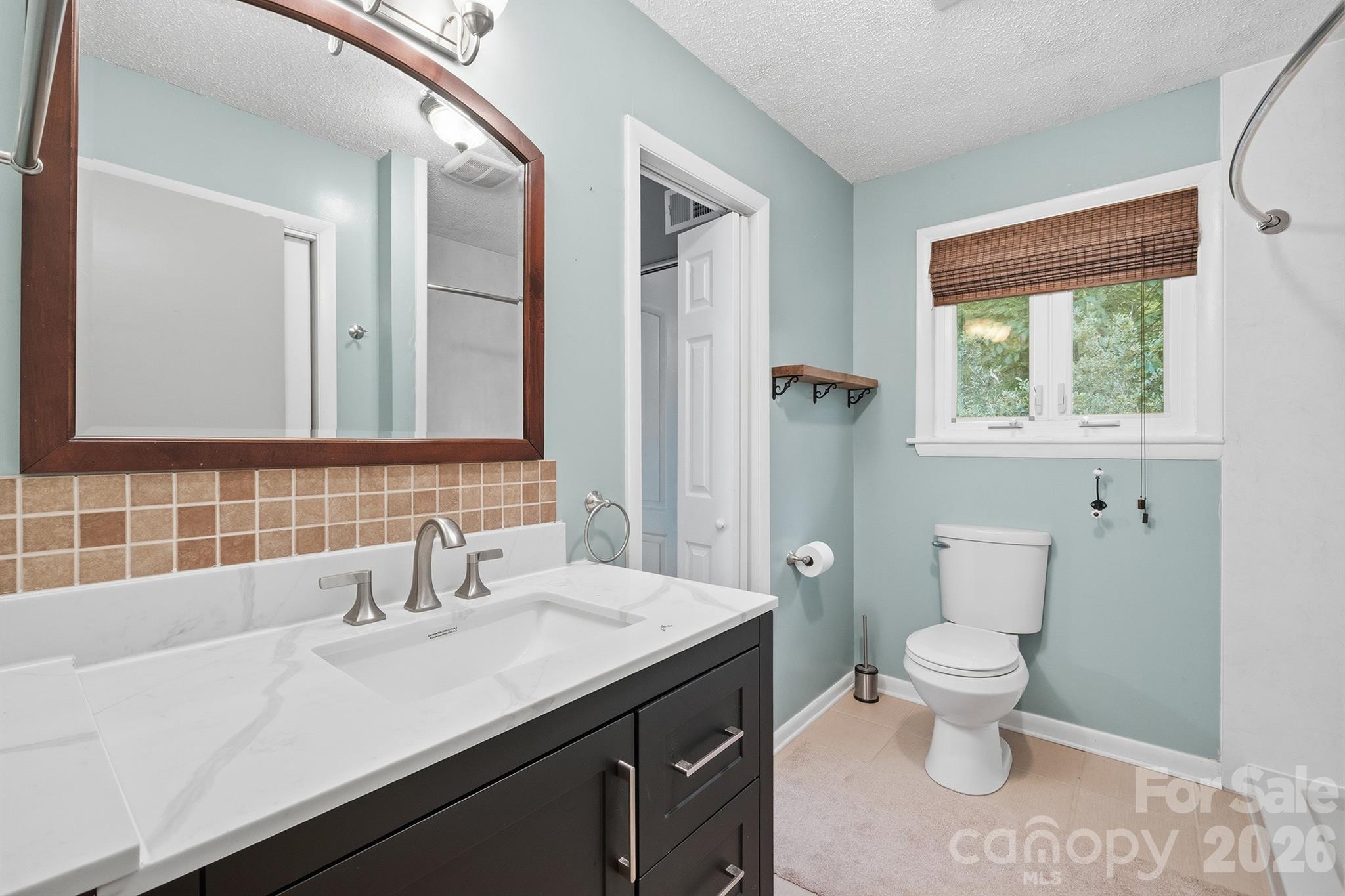 3190 Holly Road Connelly Springs, NC 28612 - Photo 26 of 42 a bathroom with a sink a toilet and a large mirror