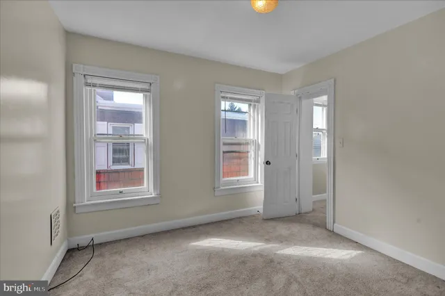 an empty room with windows and closet