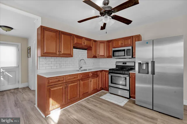 a kitchen with stainless steel appliances granite countertop a refrigerator a stove microwave and island