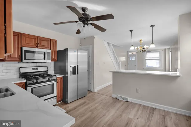 a kitchen with kitchen island white cabinets and stainless steel appliances