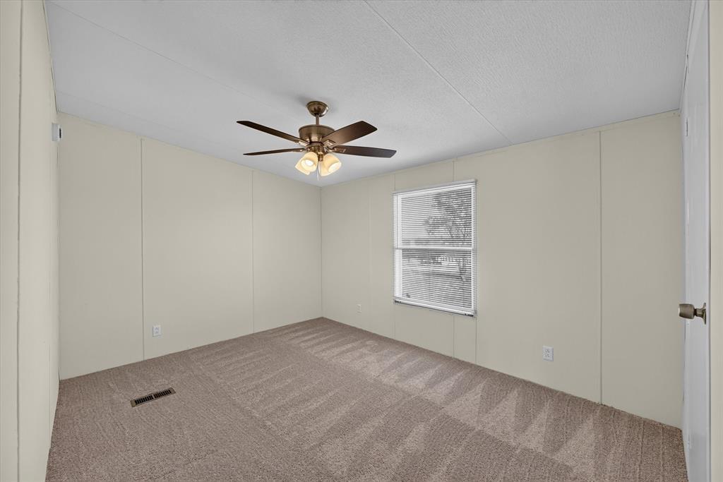 246 PR-4443 Rhome, TX 76078 - Photo 25 of 35 Carpeted room with a ceiling fan, light-colored walls, and a window providing natural illumination