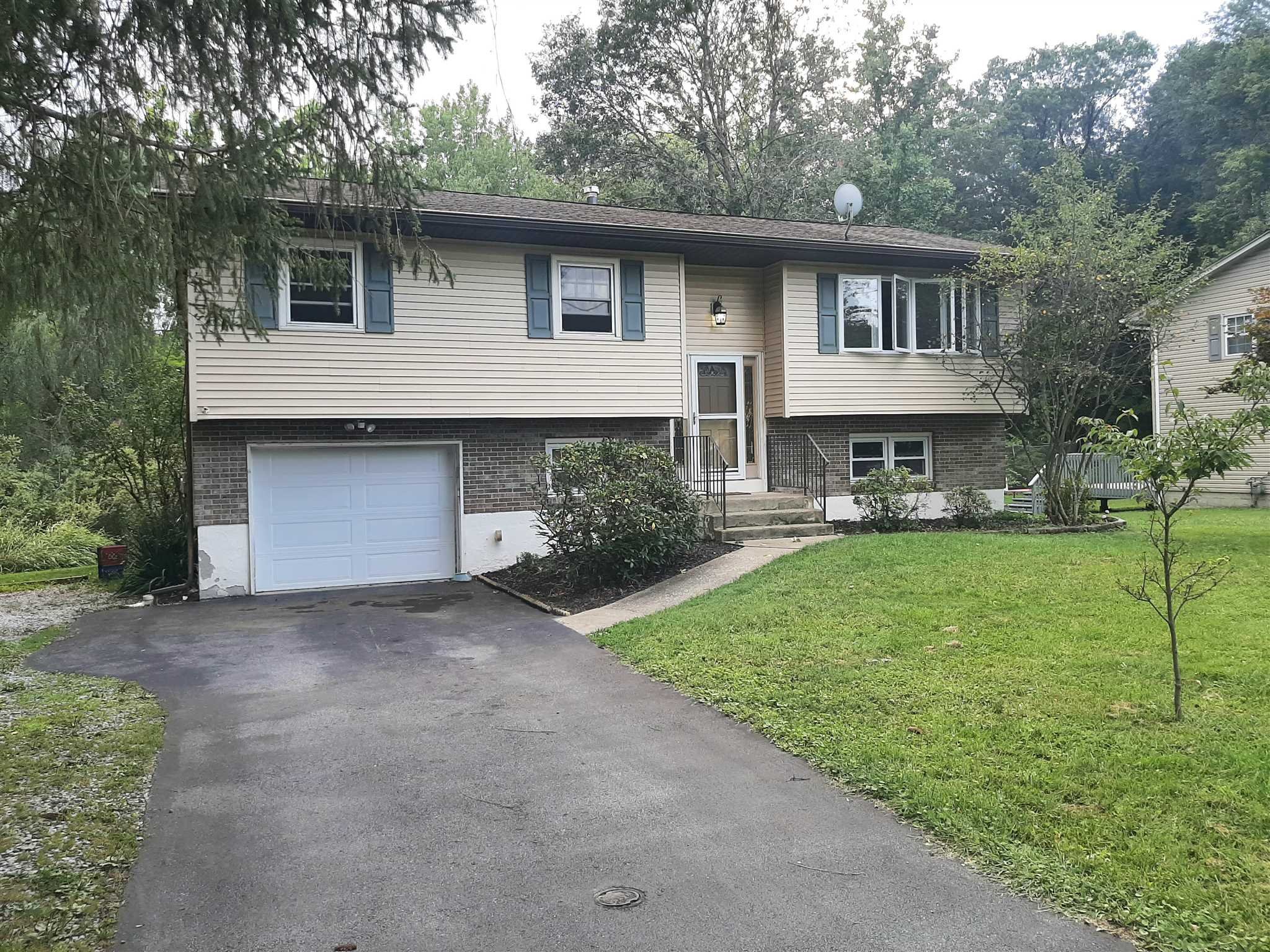 97 Sutton Park Road Poughkeepsie, NY 12603 - Photo 2 of 20 a front view of a house with a yard and garage