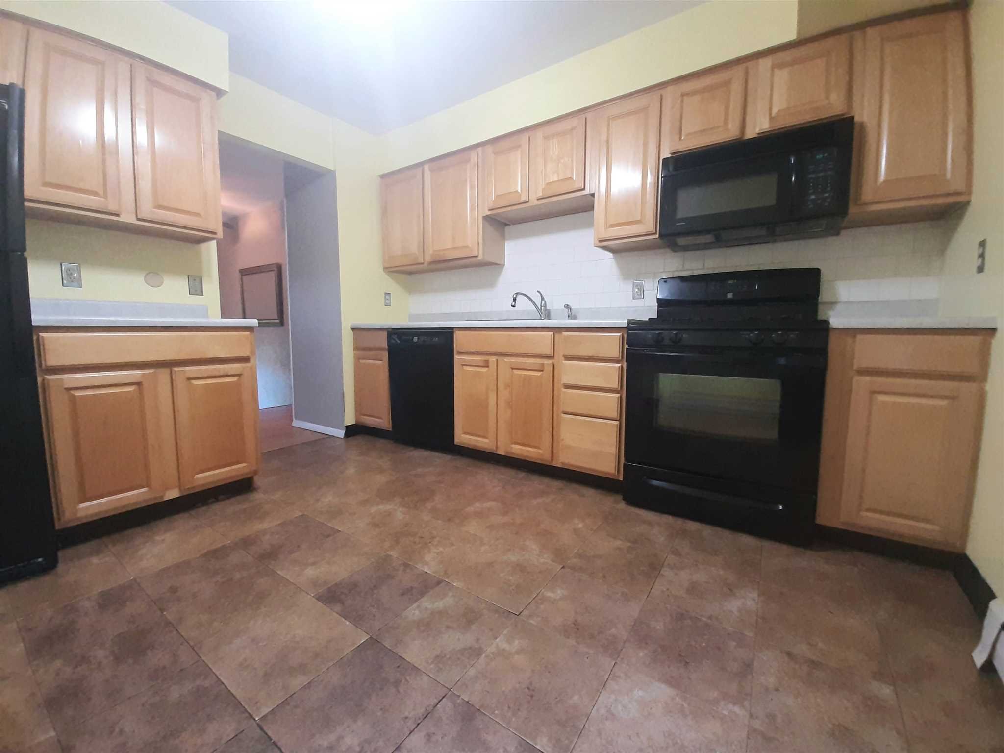 97 Sutton Park Road Poughkeepsie, NY 12603 - Photo 5 of 20 a kitchen with granite countertop a stove top oven sink and cabinets